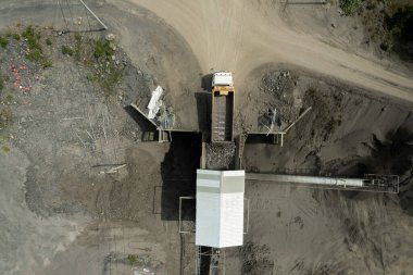 Kum yükleyicilerinin hava manzarası çöp kamyonuna taş atıyor.