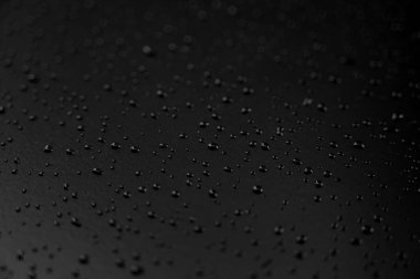 Yerde siyah arka planlı su damlacıkları var.