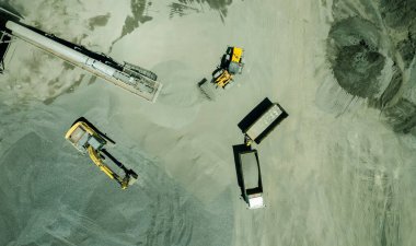 Kum yükleyicilerinin hava manzarası çöp kamyonuna taş atıyor.