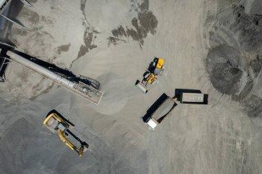 Kum yükleyicilerinin hava manzarası çöp kamyonuna taş atıyor.