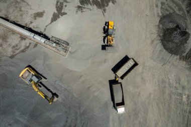 Kum yükleyicilerinin hava manzarası çöp kamyonuna taş atıyor.