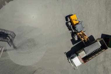 Kum yükleyicilerinin hava manzarası çöp kamyonuna taş atıyor.