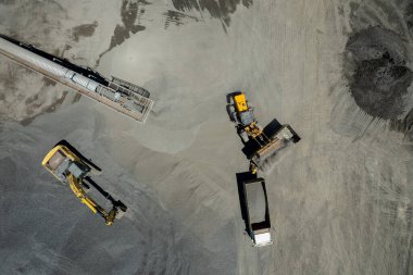 Kum yükleyicilerinin hava manzarası çöp kamyonuna taş atıyor.