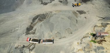 Kum yükleyicilerinin hava manzarası çöp kamyonuna taş atıyor.