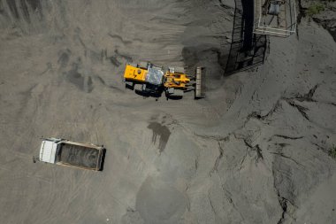 Kum yükleyicileri çöp kamyonlarına taş topluyor.