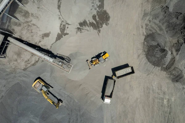 Kum yükleyicilerinin hava manzarası çöp kamyonuna taş atıyor.