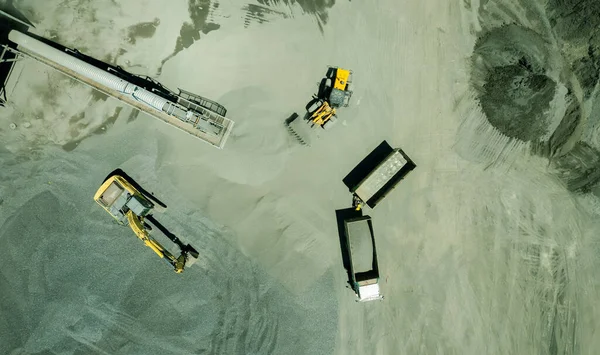 Kum yükleyicilerinin hava manzarası çöp kamyonuna taş atıyor.