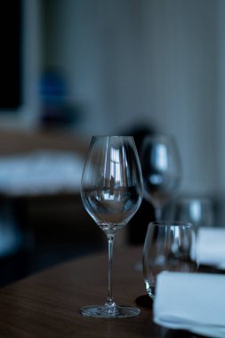 Masanın üzerinde bulanık yüzlü boş bir bardak su.