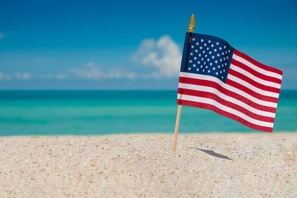 United States of America Flag. Beach and American Flag. Summer vacations. 4th of July Independence, Memorial or Presidents Day. Atlantic Ocean. Sunny day. Turquoise color of saltwater. Tropical nature