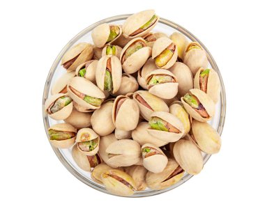 Çam fıstığı. Fıstıklı kabuklu fıstık. Cam kasede kavrulmuş ve tuzlanmış Pistachio. Beyaz arka planda izole edilmiş. Vejetaryen atıştırması. Kabuğu soyulmamış. Yüksek kalite fotoğraf. Makro yemek fotoğrafçılığını kapat..