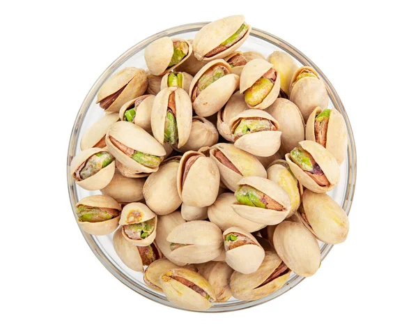 Çam fıstığı. Fıstıklı kabuklu fıstık. Cam kasede kavrulmuş ve tuzlanmış Pistachio. Beyaz arka planda izole edilmiş. Vejetaryen atıştırması. Kabuğu soyulmamış. Yüksek kalite fotoğraf. Makro yemek fotoğrafçılığını kapat..