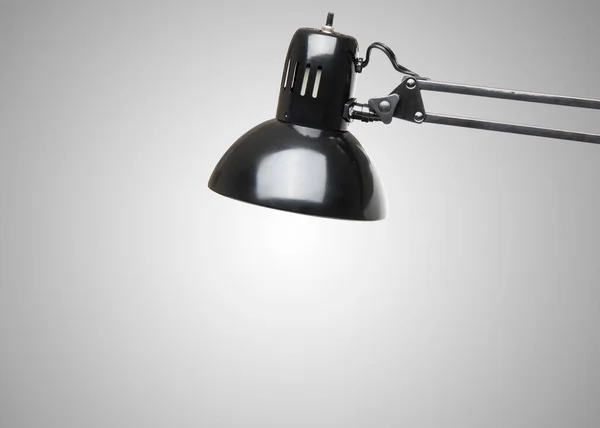 Office Desk lamp. Electric Lamp with bulb. Switched on Light. Adjustable swing arm clamp on lamp. Concept for architect, artist. Workplace. Mockup, copy space on gray wall background. Modern interior.