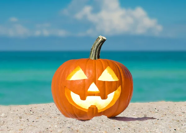 Happy Halloween. Pumpkin Jack-o\'-lantern on the beach. Jack o lantern for Halloween party. Autumn season. Blue ocean on background. Autumn season. Florida beach. Copy space.