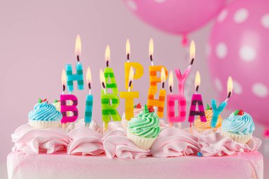 Birthday cake. Happy Birthday Candles. Birthday Colored letters and words. Pink color frosting or icing cream. Birthday cupcake. Celebrate anniversary. Event or Party. Sweet dessert. Pink air balloons
