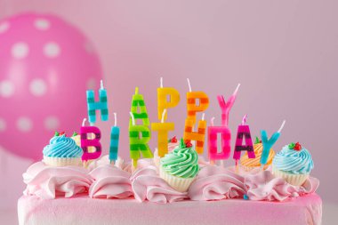 Birthday cake. Happy Birthday Candles. Birthday Colored letters and words. Pink color frosting or icing cream. Birthday cupcake. Celebrate anniversary. Event or Party. Sweet dessert. Pink air balloons