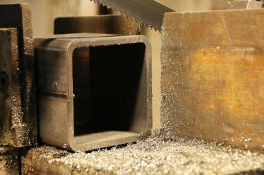 Metal testere, endüstriyel bir makinenin çelik bölümünde delikler açar. Makine mühendisliği. Tehlikeli bir iş. Metal endüstrisi.