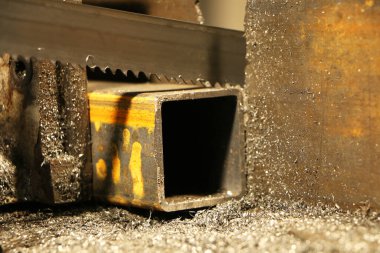 Metal testere, endüstriyel bir makinenin çelik bölümünde delikler açar. Makine mühendisliği. Tehlikeli bir iş. Metal endüstrisi.