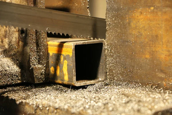 Metal testere, endüstriyel bir makinenin çelik bölümünde delikler açar. Makine mühendisliği. Tehlikeli bir iş. Metal endüstrisi.