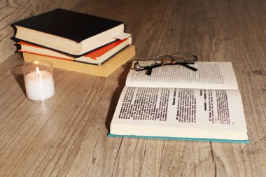 Tahta bir masada yanan bir mumla üniversitedeki sınavlara hazırlanıyorum. Bilimsel bir makale yaz. Kütüphanede bilimsel materyal çalışması..