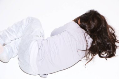 Küçük kız manken beyaz arka planda pijamalarıyla uyuyor. Kız geri kalanı için kıyafetlerini gösteriyor.. .