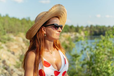 Portre. Doğanın arka planında hasır şapkalı bir kadın.