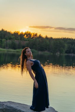 Woman in dress on the background of the sunset.