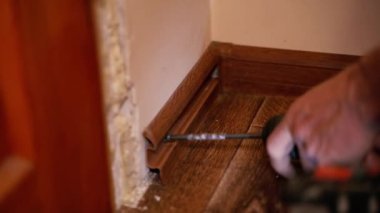 Construction works. Dismantling the skirting board. Close-up.