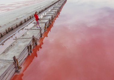 Pembe göl. Pembe gölün arka planında poz veren bir turist. Tuz özütü. Hava görünümü.