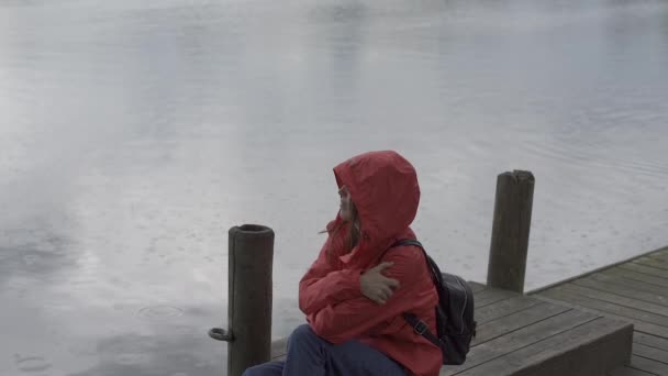 一个女人坐在公园里 雨滴在她身上 — 图库视频影像