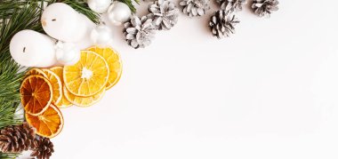 Noel Afişi. Kış, yeni yıl kompozisyonu. Firavun ağacı dalları, çam kozalakları, beyaz arka planda kurutulmuş portakallar. Düz konum, üst görünüm, kopyalama alanı.