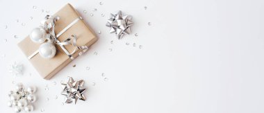 Beyaz arka planda Noel hediyesi ve konfetiden yapılmış pankart. Mutlu Noeller, yeni yıl tatili konsepti. Düz konum, üst görünüm, kopyalama alanı