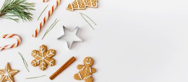 Noel Afişi. Kış, yeni yıl kompozisyonu. Tarçın çubuklarından, şekerlerden, beyaz arka planda zencefilli ekmekten yapılmış Noel çerçevesi. Düz konum, üst görünüm, kopyalama alanı.