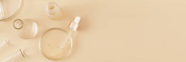 Banner, bej arka planda serum ve yağ ile laboratuvar cam pipeti yaptı. Doğal ilaçlar, kozmetik araştırmalar, biyoloji, organik cilt bakım ürünleri. Cilt bakımı. Düz, üst görünüm..