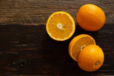 Olgun portakallar ahşap bir masada ikiye bölünmüş. Metin için boş alan. En üstten görüntüle.