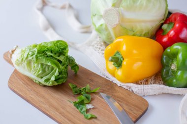 Marul mutfak masasındaki kesme tahtasında dolma biber ve lahana hamamböceğinin yanında. Sağlıklı yemek teması.