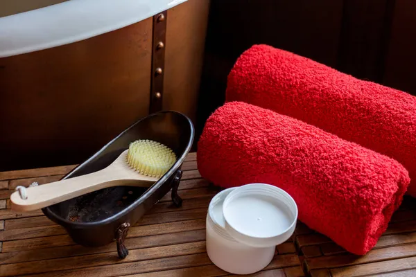 Twee Rode Badstof Handdoeken Badborstel Een Pot Crème Liggen Tafel — Stockfoto