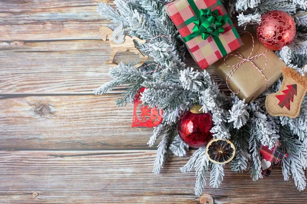 Paketli hediyeli bir Noel çelengi ve diğer güzel yılbaşı süsleri ahşap bir arka planda. Metin için boş alan. En üstten görüntüle.