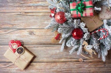 Paketli hediyeli bir Noel çelengi ve diğer güzel yılbaşı süsleri ahşap bir arka planda. Metin için boş alan. En üstten görüntüle.