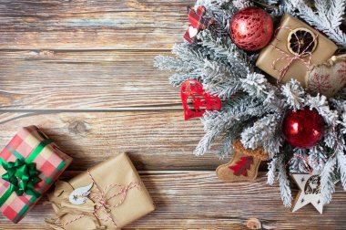 Paketli hediyeli bir Noel çelengi ve diğer güzel yılbaşı süsleri ahşap bir arka planda. Metin için boş alan. En üstten görüntüle.