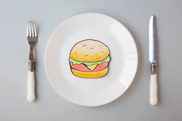 Painted Hamburger Lies White Plate Next Knife Fork Gray Background — Stock Photo, Image