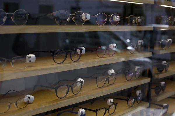 Glasses for vision are presented on the shelves of the shop window.
