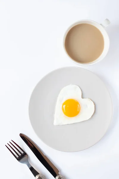 Tabakta Kızarmış Kalp Şeklinde Yumurta Arka Planda Bir Fincan Kahve Stok Fotoğraf