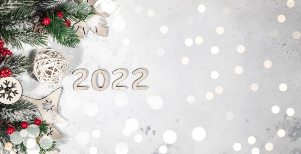 Mutlu yıllar 2022 afişleri, köknar dalları, kırmızı Noel topları ve ışıklarıyla süslenmiş yeni yıl ışığı arka planı, bokeh ışıkları ve metin için boş alan