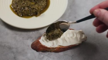 Eller pesto sosu, sandviçler çavdar ekmeği, krem peynir ve yeşil pesto