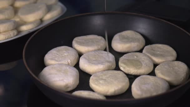 Verter aceite de girasol en la sartén con buñuelos de cuajada, freír panqueques de requesón, concepto de cocina casera — Vídeo de stock