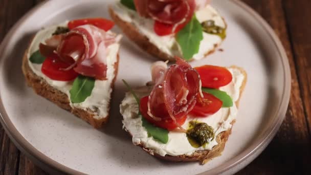 Vrouw hand neemt ham kaas sandwich van plaat, eten bruschetta als ontbijt, close-up — Stockvideo