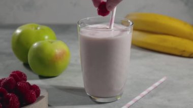 Bardağa meyveli yoğurt, elma ve ahududulu milkshake, yoğurt içeceği ve masadaki malzemeler.