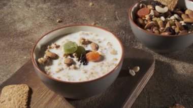 Sağlıklı kahvaltı. Süt, fındık ve kuru meyveli yulaf ezmesi veya müsli, bağışıklığı artırmak için yurtiçi kahvaltı
