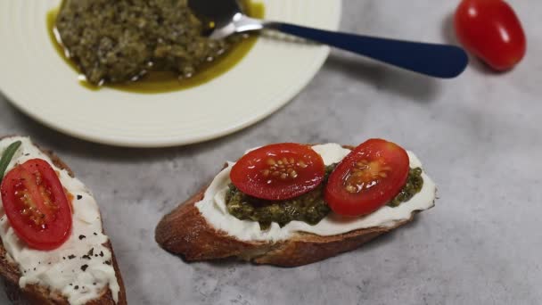 Cozinhar sanduíches em casa, mão colocar verdes em pão de fatia com queijo cottage e molho pesto — Vídeo de Stock