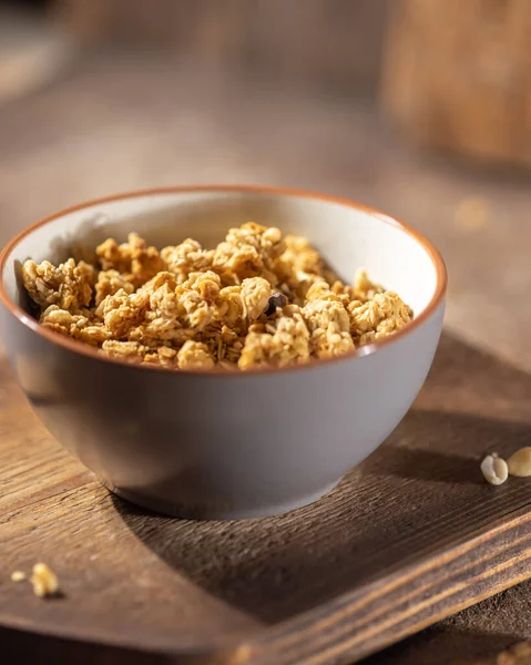 Healthy lifestyle breakfast, granola bowl on brown wooden table background, cereal granola or organic seed muesli